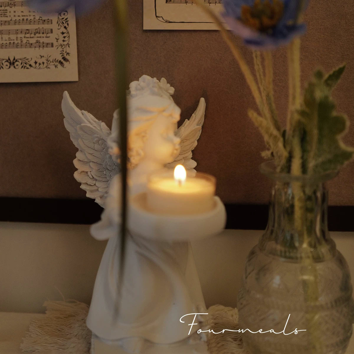 White angel candle holder in a softly lit room