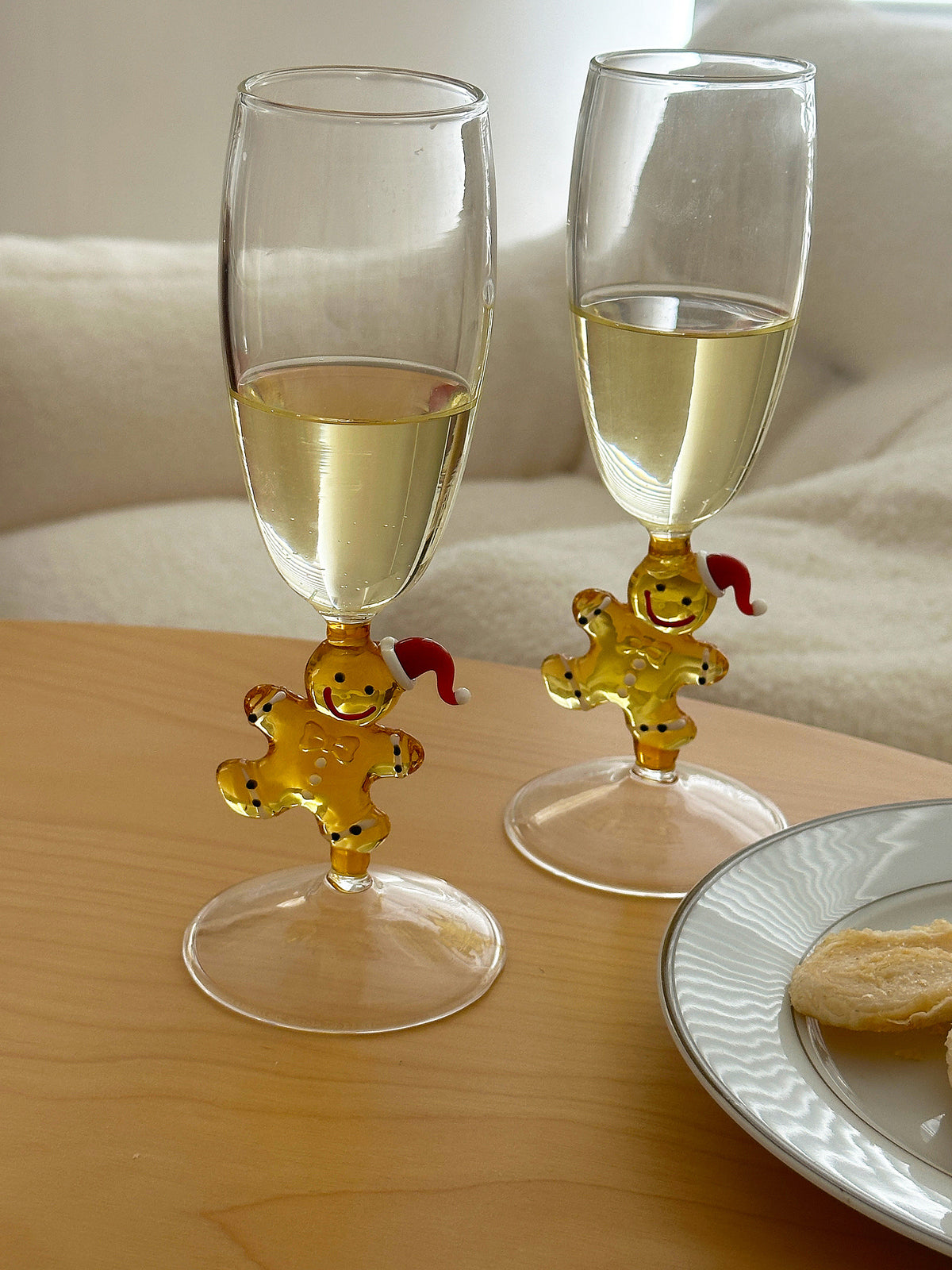 Two festive gingerbread champagne glasses on a tabletop