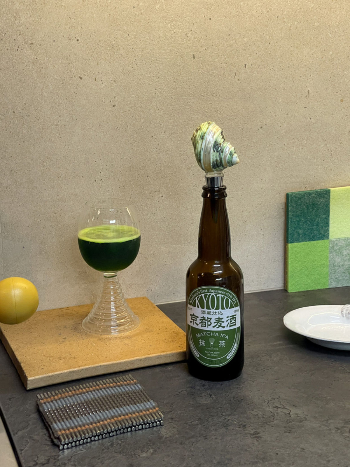 Natural seashell wine stopper used in a green bottle on a styled dining table