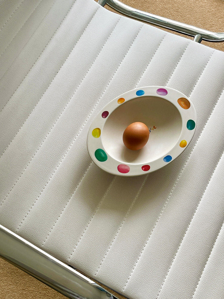 SoftServe colorful candy bean bowl holding an egg on a white chair