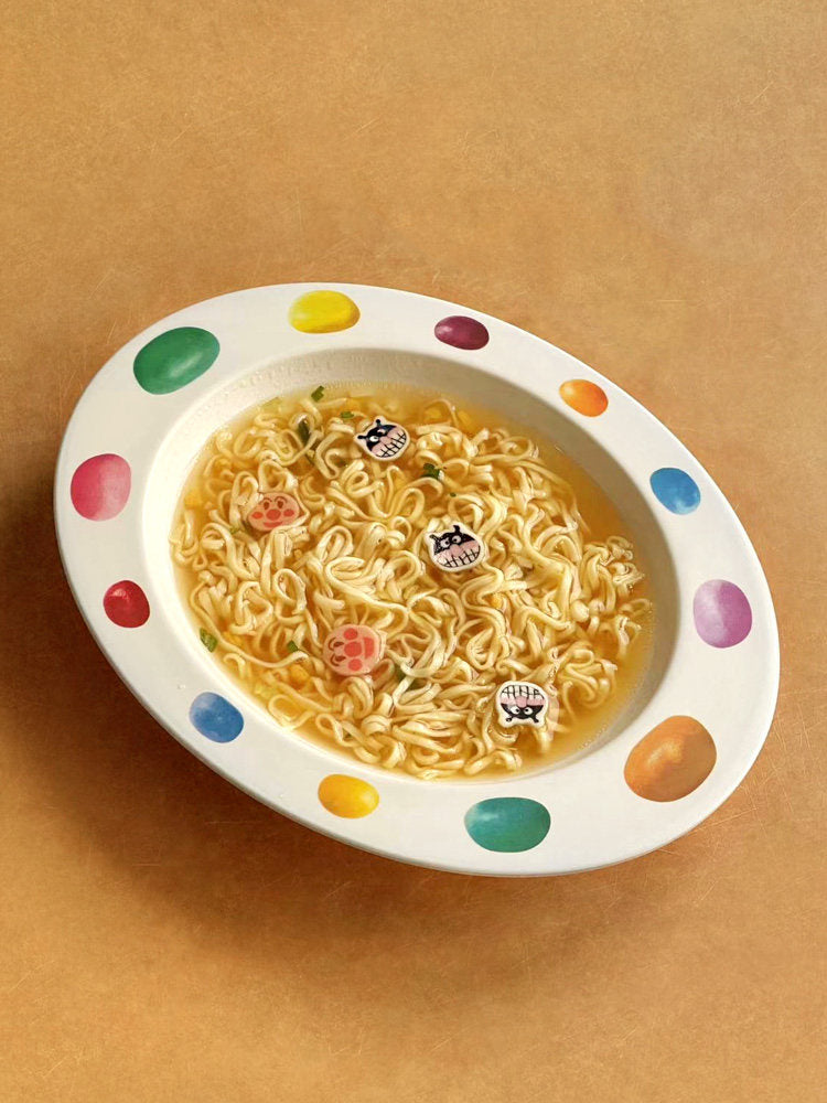 SoftServe colorful candy bean bowl filled with noodles on a tan tabletop