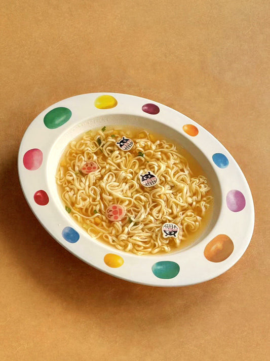 SoftServe colorful candy bean bowl filled with noodles on a tan tabletop
