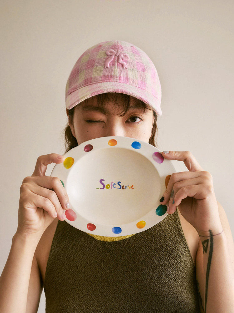 Person holding an empty SoftServe colorful candy bean bowl in front of their face
