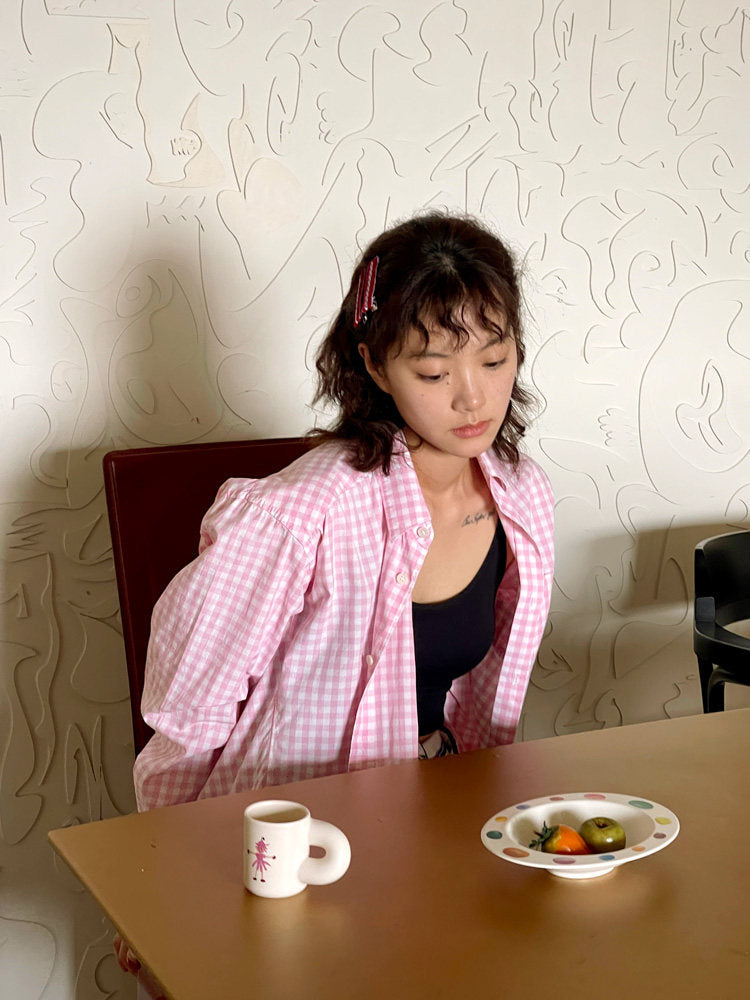 Woman seated at a table with a SoftServe candy bean bowl and ceramic mug