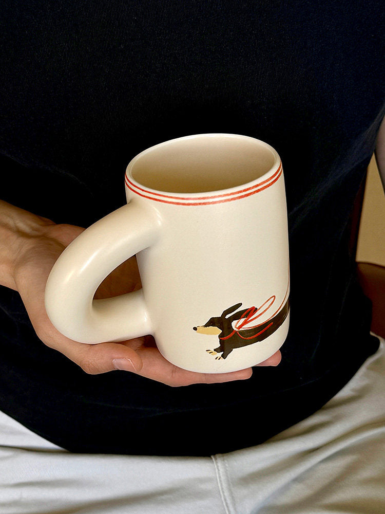 Person holding a SoftServe dachshund ceramic mug