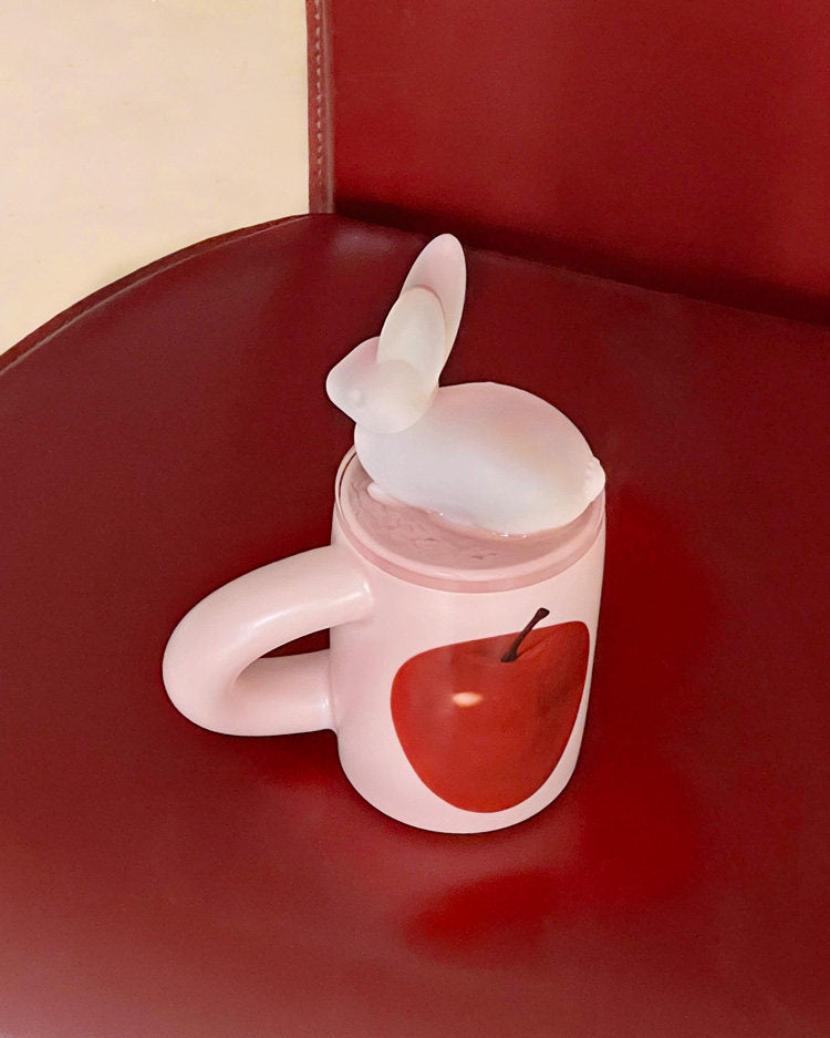 SoftServe red apple mug with a white character spoon on a red chair