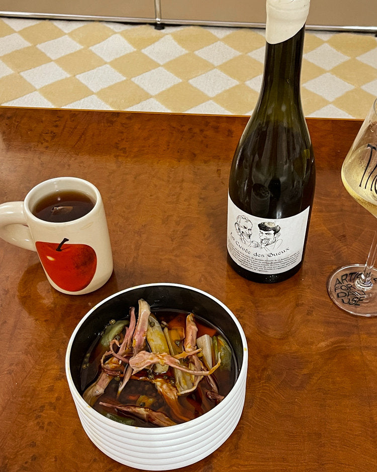 SoftServe red apple mug beside a pasta bowl and wine bottle