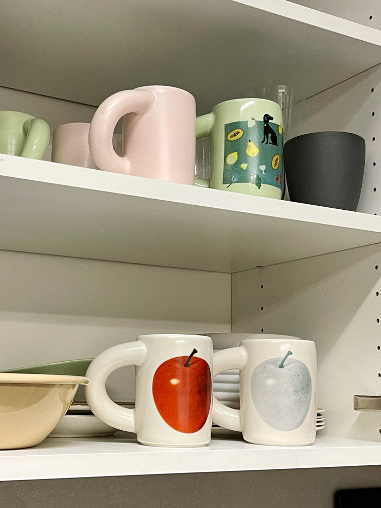 SoftServe apple, pear and character mugs displayed on kitchen shelves