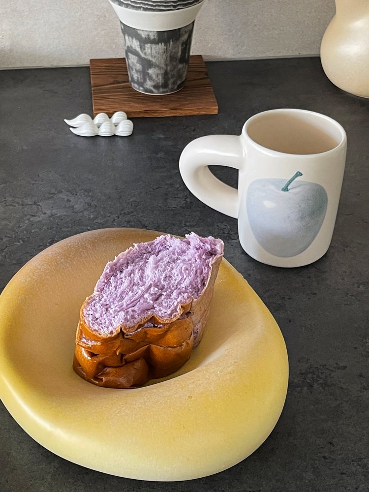 SoftServe pale pear ceramic mug beside toast on a dark tabletop