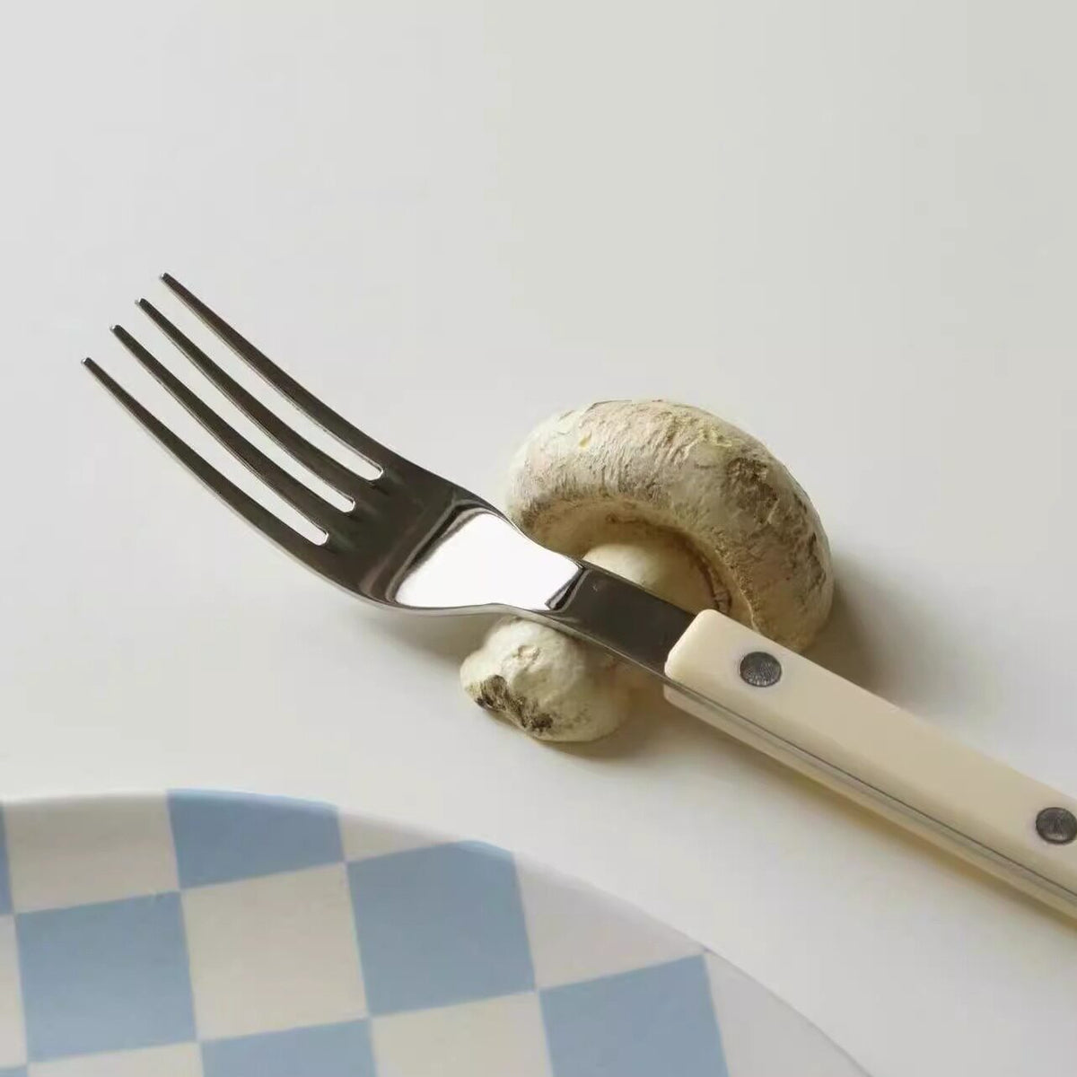 Fork resting on a white Shinymomo mushroom-shaped cutlery rest