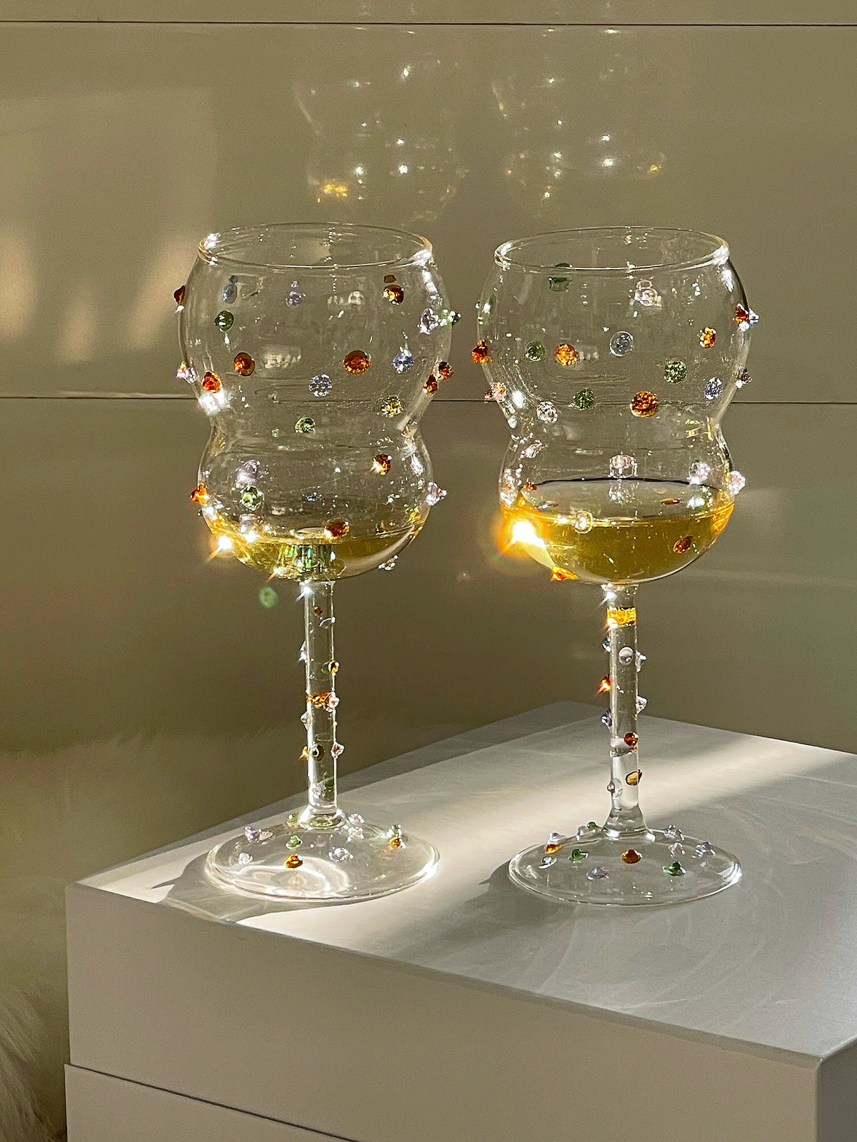 Clear gemstone-dotted wine glass in a styled tabletop setting