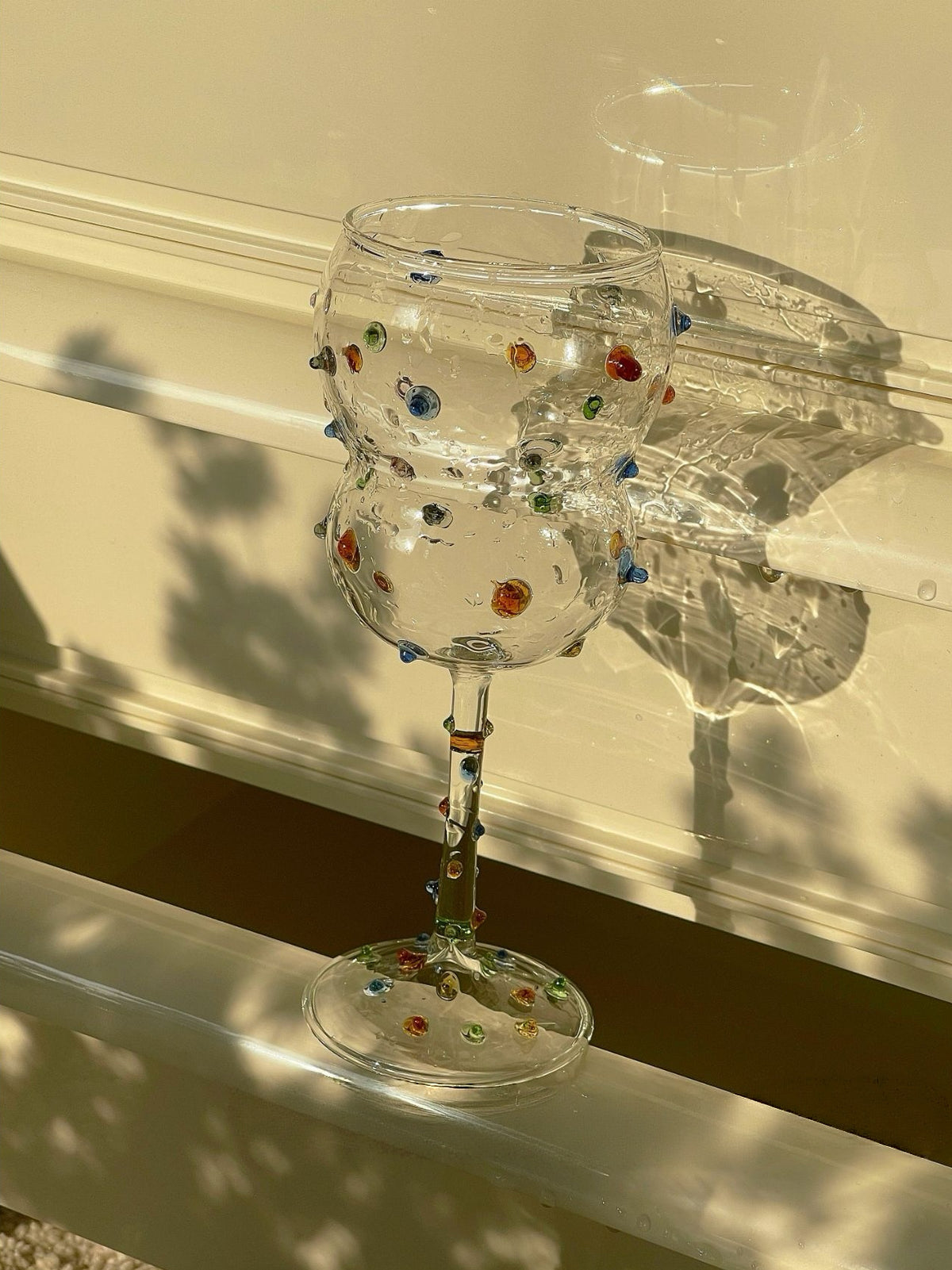 Colorful glass gem details on a sculptural wine glass