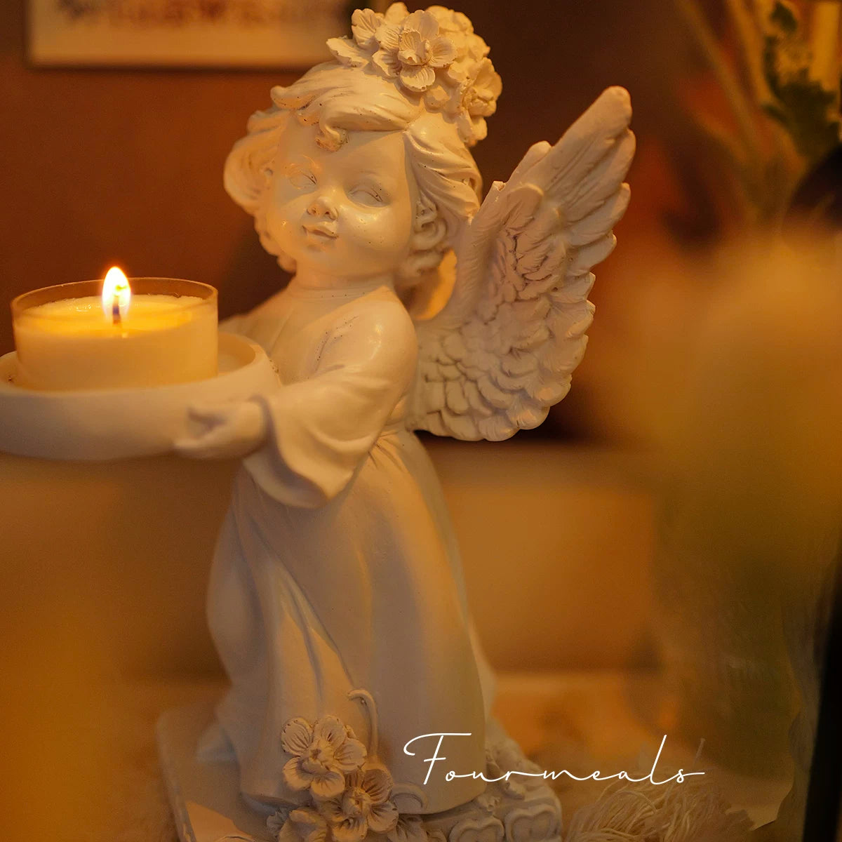 White angel candle holder glowing in a warm interior