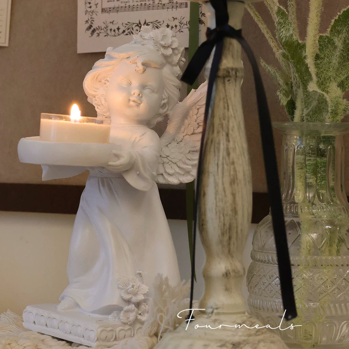 Angel tealight holder styled with flowers and glassware