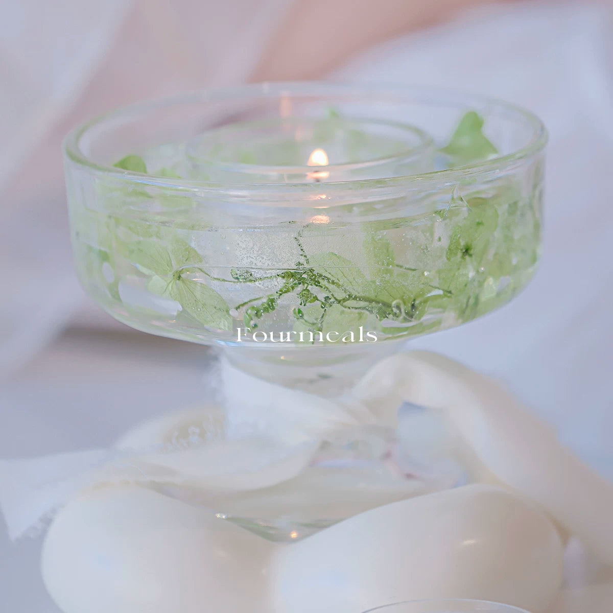 Close-up of green dried flowers in a glass tealight holder