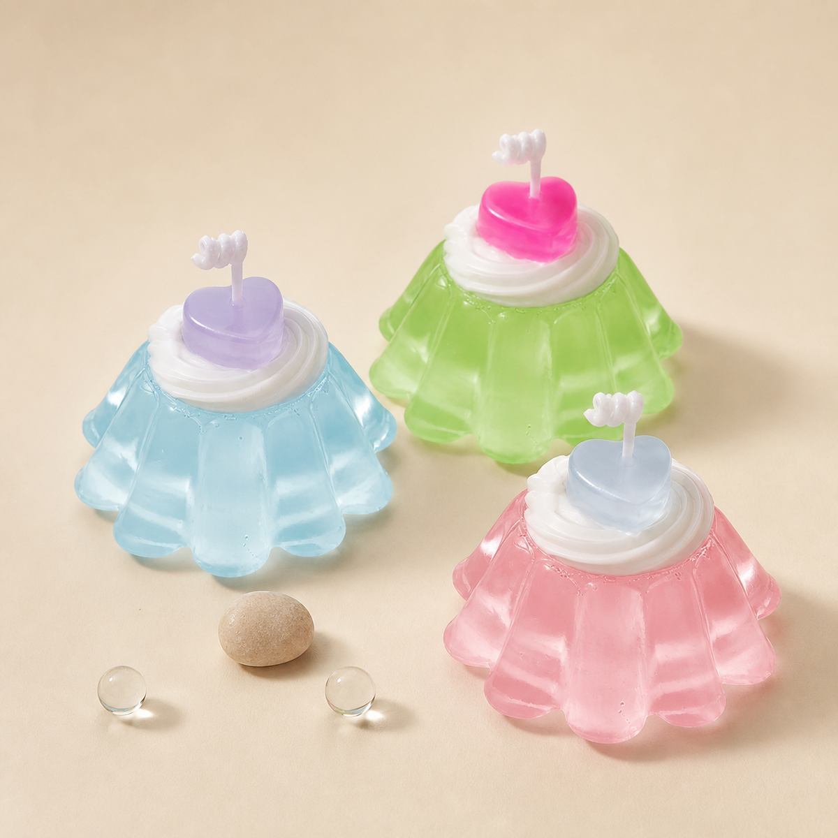 HollyJelly pudding candles in pastel colors on a warm ivory background