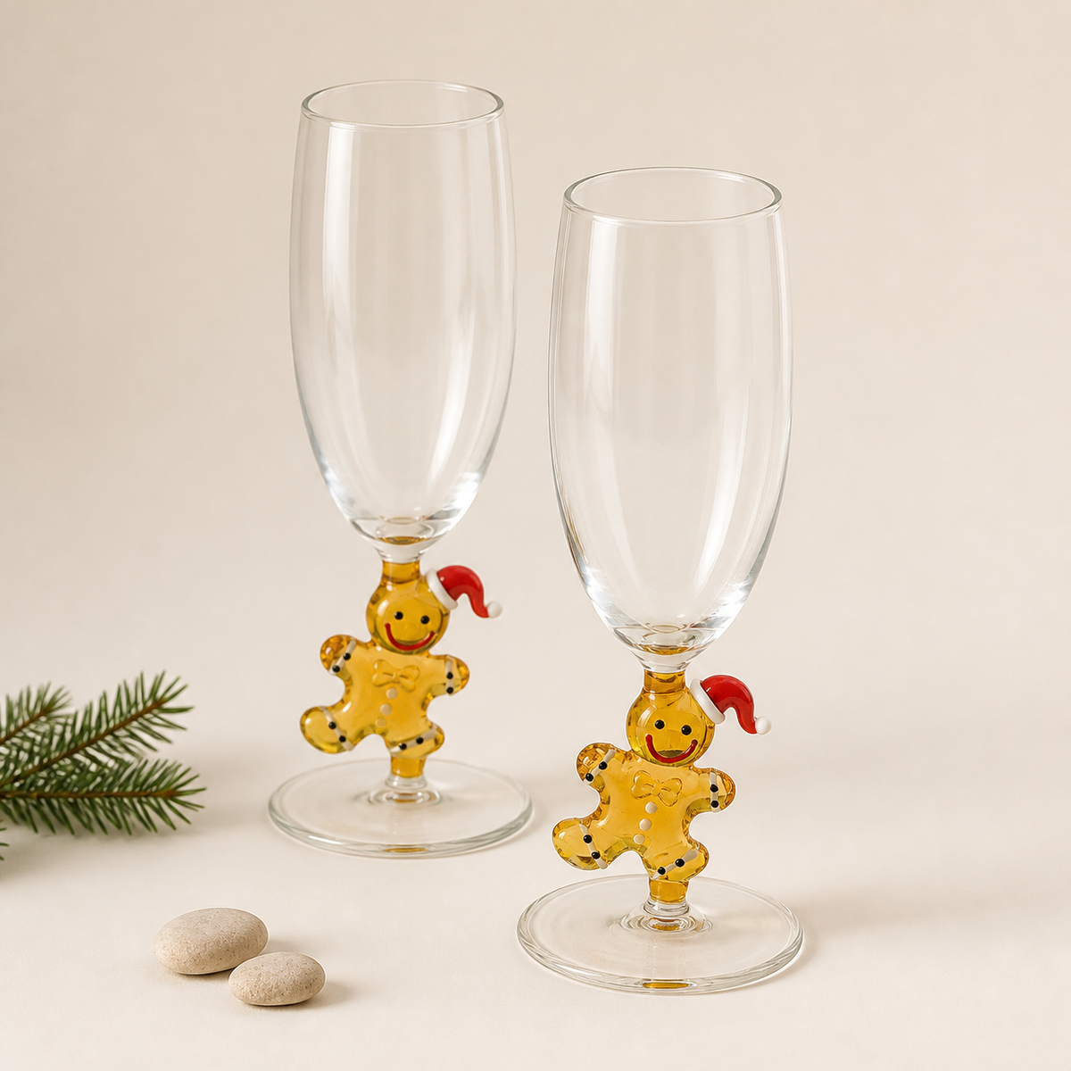 Two gingerbread character champagne glasses on a warm white background