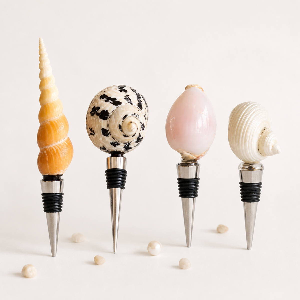 Four natural seashell wine stoppers on a warm white background